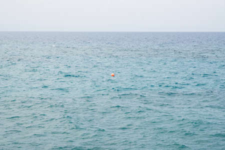 Red Buoy Floating in a Mediterranean Sea. Marking an End of a Safe Swimming Zone.の写真素材