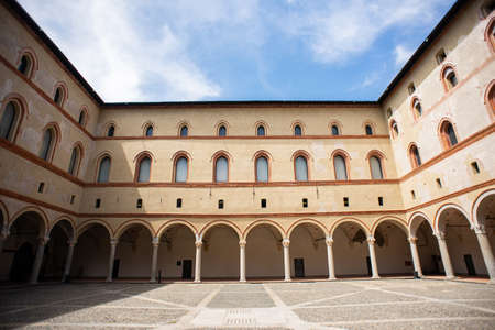 Milan. Italy - May 21, 2019: Courtyard of Sforza Castle (Castello Sforzesco). Beige Yellow Walls with Arched Windows and Columns.のeditorial素材