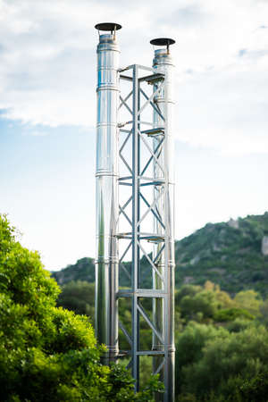 Galvanized Pipes of Small Modern Power Station on Sky Background. Steel Tower with Two Steel Pipes...