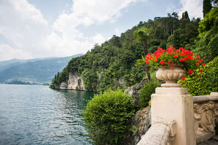 Villa Balbianello. Lake Como. Italy - July 19, 2019: Stunning Landscape on Lake Como. Italy. Stone Vase with Flowers in the Park of Villa del Balbianello.のeditorial素材