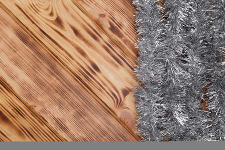 Silver christmas tinsel on wooden backgroundの写真素材
