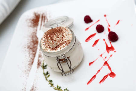 gourmet ice cream in a glass jar on a white plateの写真素材