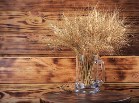ceramic beer mug with wheat on wooden backgroundの写真素材