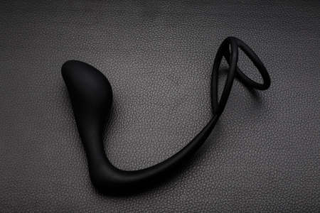 Black silicone prostate massager on black leather. Anal plug.の写真素材
