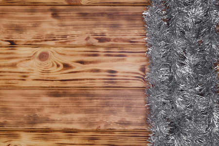 Silver christmas tinsel on wooden backgroundの写真素材