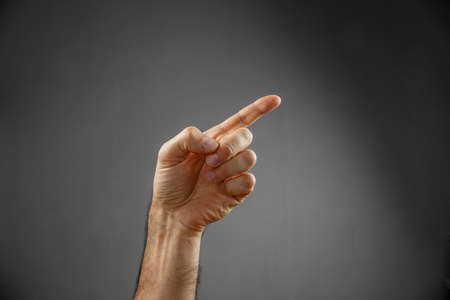 hand on a gray background. pointing gestureの写真素材