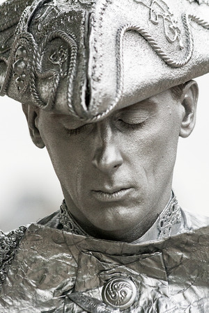 A portrait of a street entertainer in London  The man is dressed in 18th century costume and is painted entirely in silver paint のeditorial素材