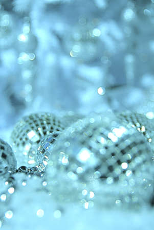 ornaments in the snow with white christmas tree in soft focusの写真素材