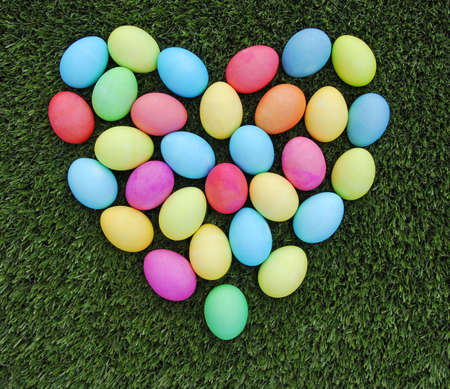 colorful easter egg heart on the green grassの写真素材