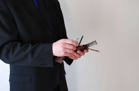 businessman holding a wallet and a credit card over whiteの写真素材