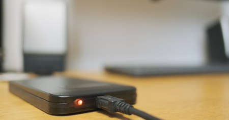Blinking indicator light during external hard drive operation, data exchange, close-up. HDD lies on...