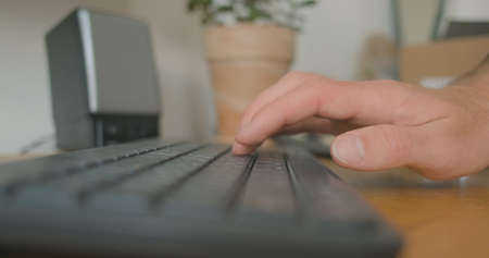 Mans hand starts typing on computer keyboard. Close-up, side view. Concept of beginning work, study, correspondence. Work at the computer keyboard, two hands.の写真素材