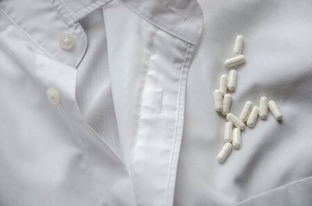 White capsules on the white shirtの写真素材