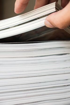 Taking book from stack of magazine