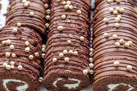 Close up beautiful chocolate Yam Roll  in white plateの写真素材