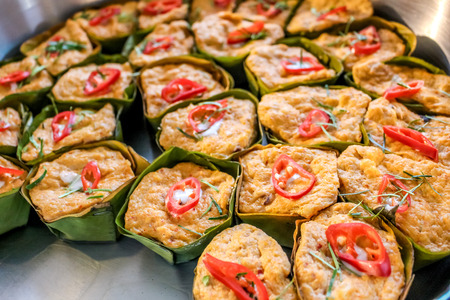 Thai steamed curry fish in banana leaf cups decorated with red chilli, (Hor Mok Pla)の写真素材