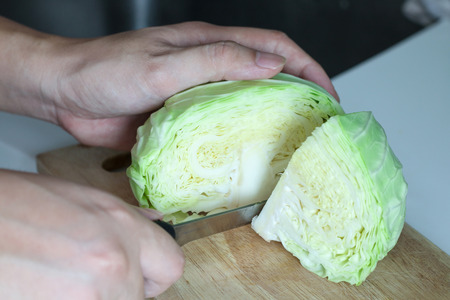 Chef hand used his knife chopping cabbage on a wooden boardの写真素材