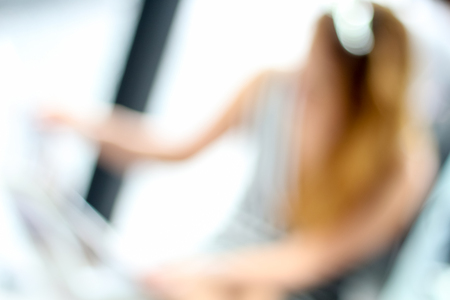 Blurred unrecognized woman reading newspaper in the shop cafeの写真素材