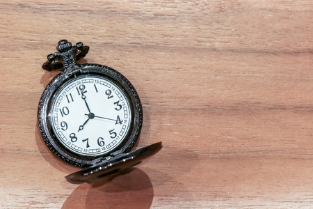 Luxury pocket watch on the wooden table with copy space