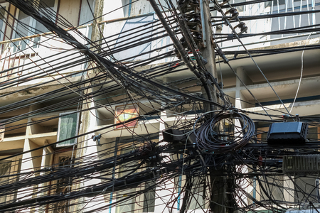 Chaos of cables and wires on electric pole in Bangkok, Thailand