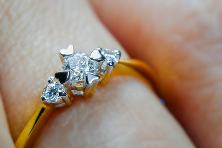 Closeup macro adorable gold diamond wedding and engagement ring on the fingerの写真素材