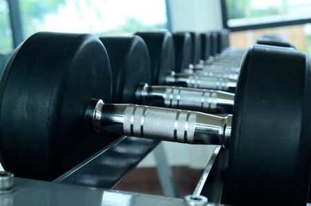 Stack of black dumbbells on weight holderの写真素材
