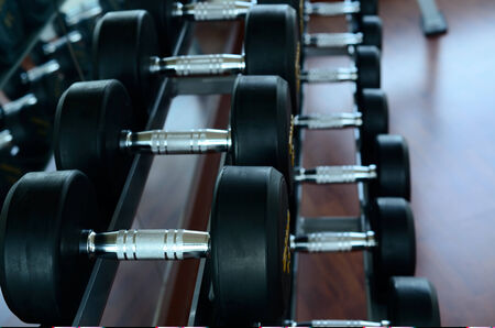 Stack of black dumbbells on weight holderの写真素材