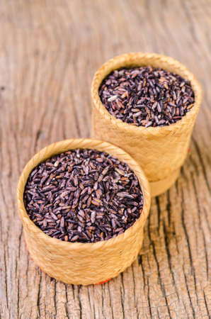 raw brown sticky rice on bamboo basketの写真素材