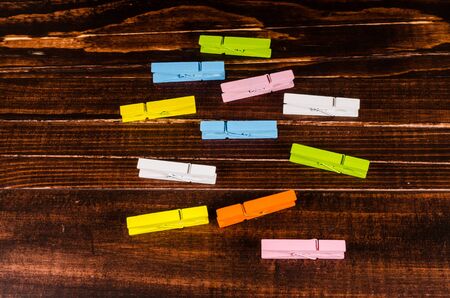 Colorful wooden clothespins on wooden background
