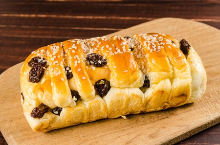 Raisin cinnamon  bread with sesame on wooden background