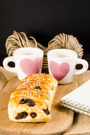 Raisin cinnamon  bread with sesame on wooden background,coffee cupの写真素材