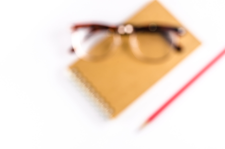 Blur of notebook with Glasses and wooden pencil isolated on white backgroundの写真素材