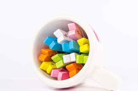Group colorful pastel of wooden clothespins in coffee cup  isolated on white backgroundの写真素材