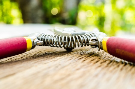 Red garden secateurs on old wooden tableの写真素材