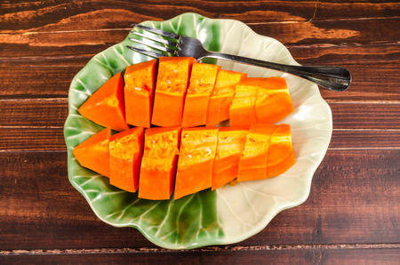 Arrange fresh papaya on green leaf dish on wooden backgroundの写真素材