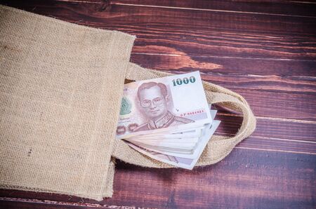 thai banknote in sack bag on wooden backgroundの写真素材