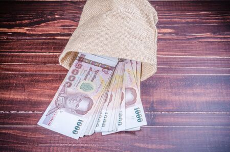 thai banknote in sack bag on wooden backgroundの写真素材