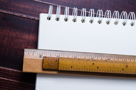 Wooden ruler and notebook on wooden board backgroundの写真素材