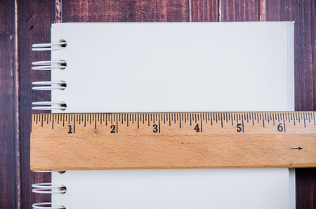 Wooden ruler and notebook on wooden board backgroundの写真素材