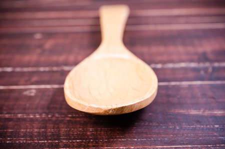 wooden spoon isolated on wooden backgroundの写真素材