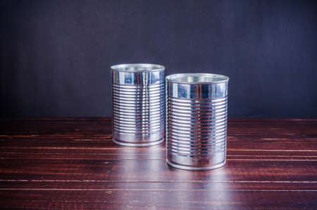 empty food tin can on wooden board background