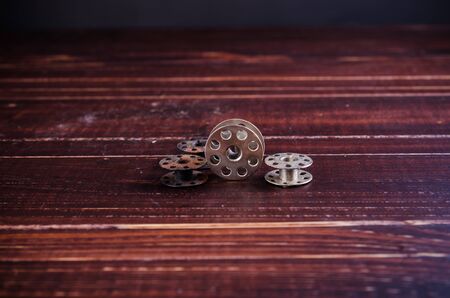 old sewing machine bobbins on wooden backgroundの写真素材