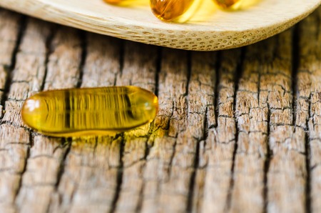 Fish oil on wooden spoon with wooden texture backgroundの写真素材