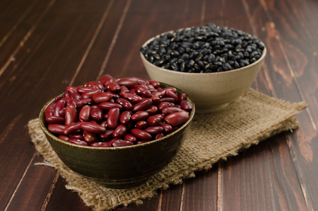 kidney bean and black bean in ceramic bowl on wooden boardの写真素材