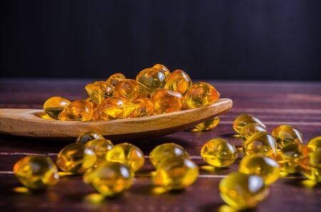Fish oil on wooden spoon with wooden texture backgroundの写真素材