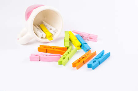 Group colorful pastel of wooden clothespins in coffee cup  isolated on white background