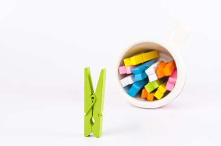 Group colorful pastel of wooden clothespins in coffee cup  isolated on white background