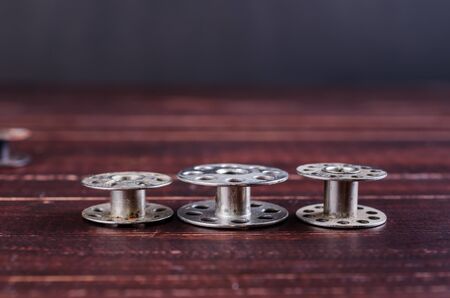 old sewing machine bobbins on wooden backgroundの写真素材