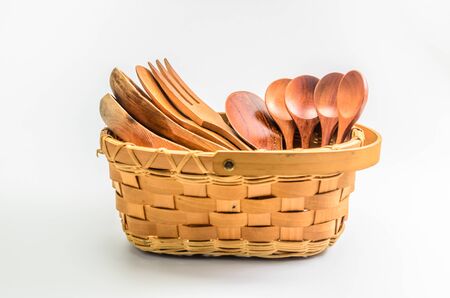 old retro wooden spoon and fork in wicker basket on white backgroundの写真素材