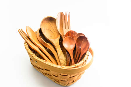 old retro wooden spoon and fork in wicker basket on white background